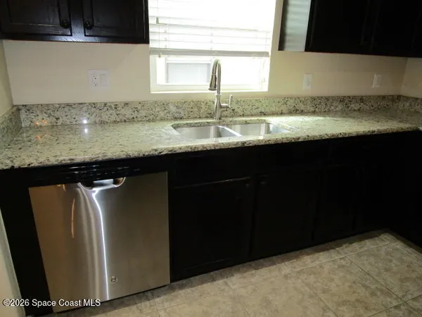a kitchen with granite countertop a sink and a window