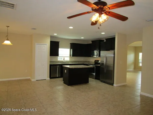 a large kitchen with a large counter space a sink stainless steel appliances and cabinets