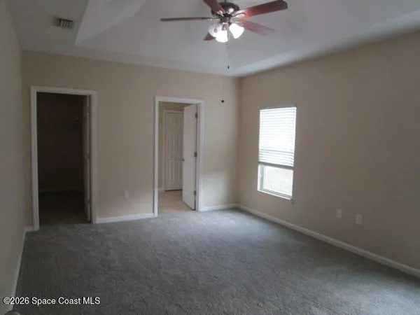 an empty room with a empty space and a ceiling fan