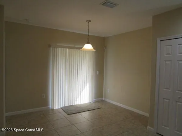 a view of a room with a chandelier fan and a window