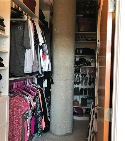 a view of walk in closet with clothes and shoes