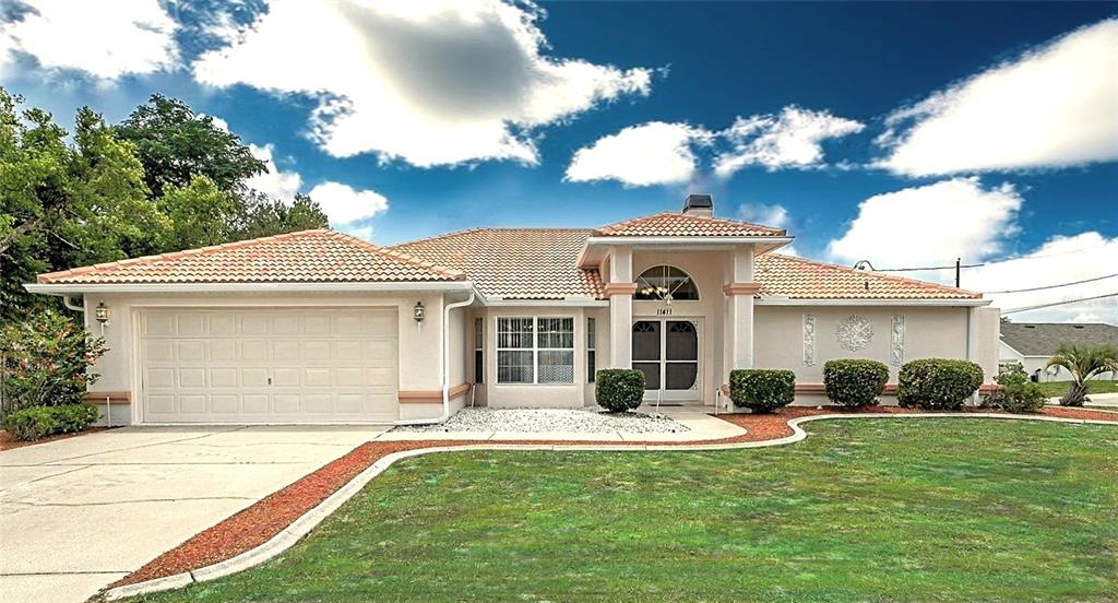11411 Terrell Road Spring Hill, FL 34608 - Photo 1 of 1 a front view of a house with garden