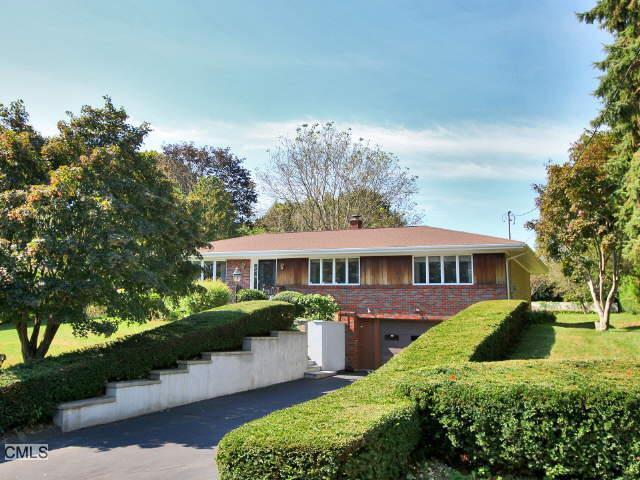 a view of a house with a big yard plants and large trees