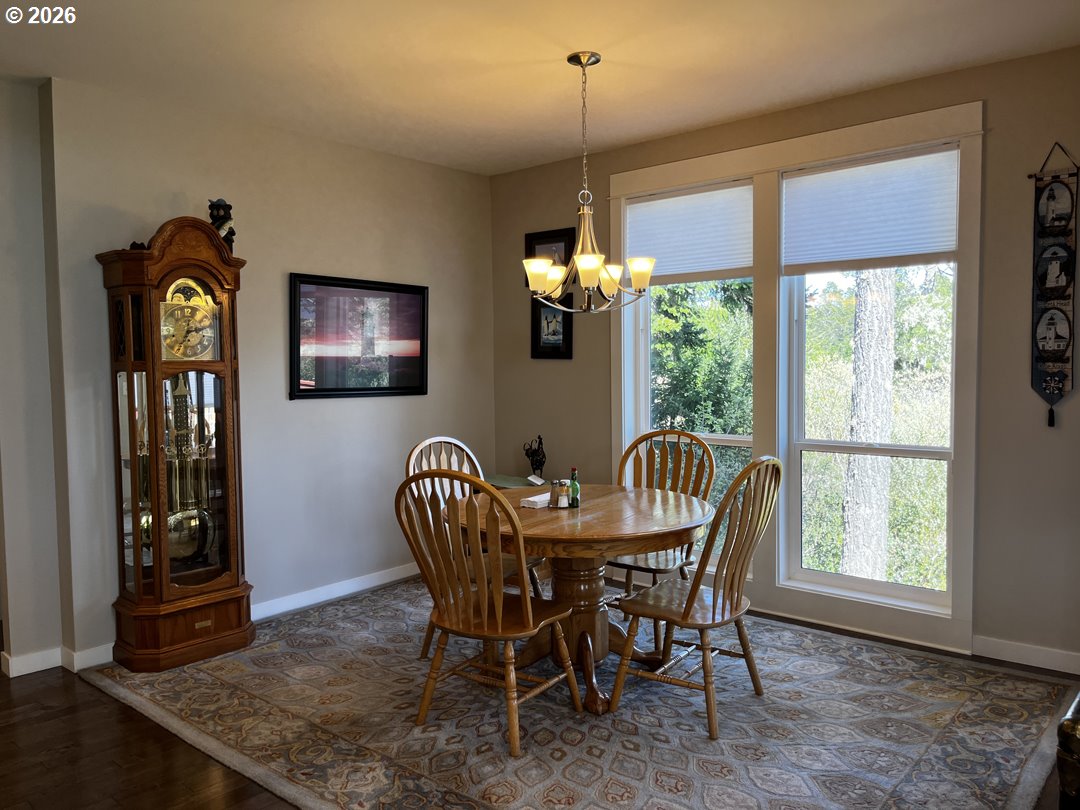 88097 Lake Point Drive Florence, OR 97439 - Photo 20 of 48 a dining room with furniture a chandelier and wooden floor