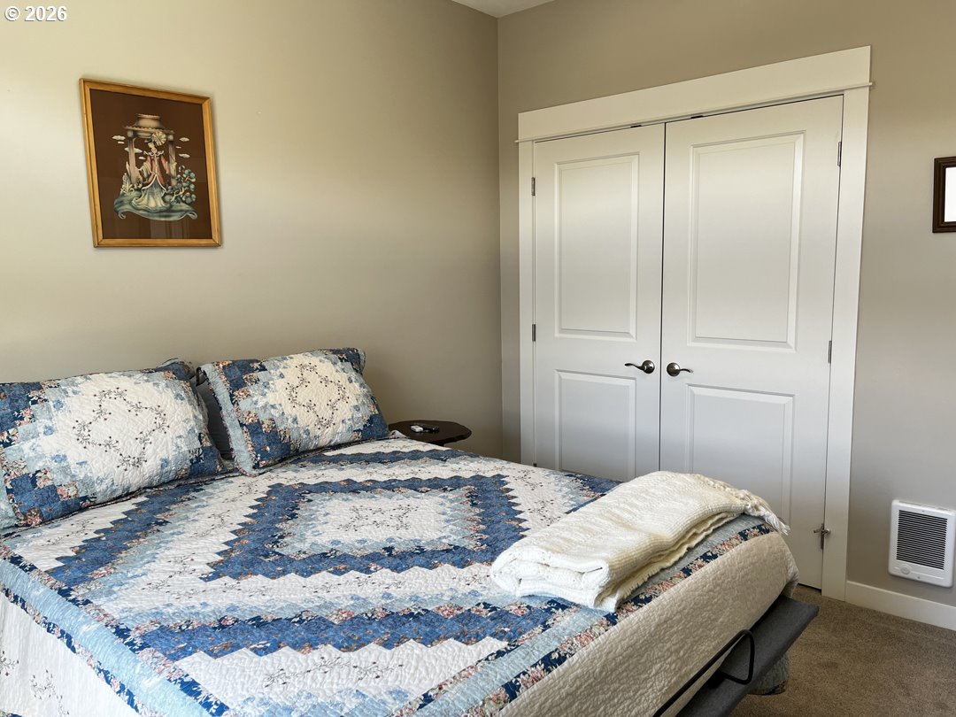 88097 Lake Point Drive Florence, OR 97439 - Photo 30 of 48 a bedroom with a bed and a painting on the wall