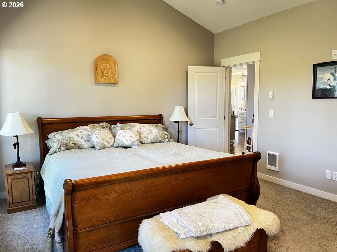 88097 Lake Point Drive Florence, OR 97439 - Photo 34 of 48 a bedroom with a bed and a lamp