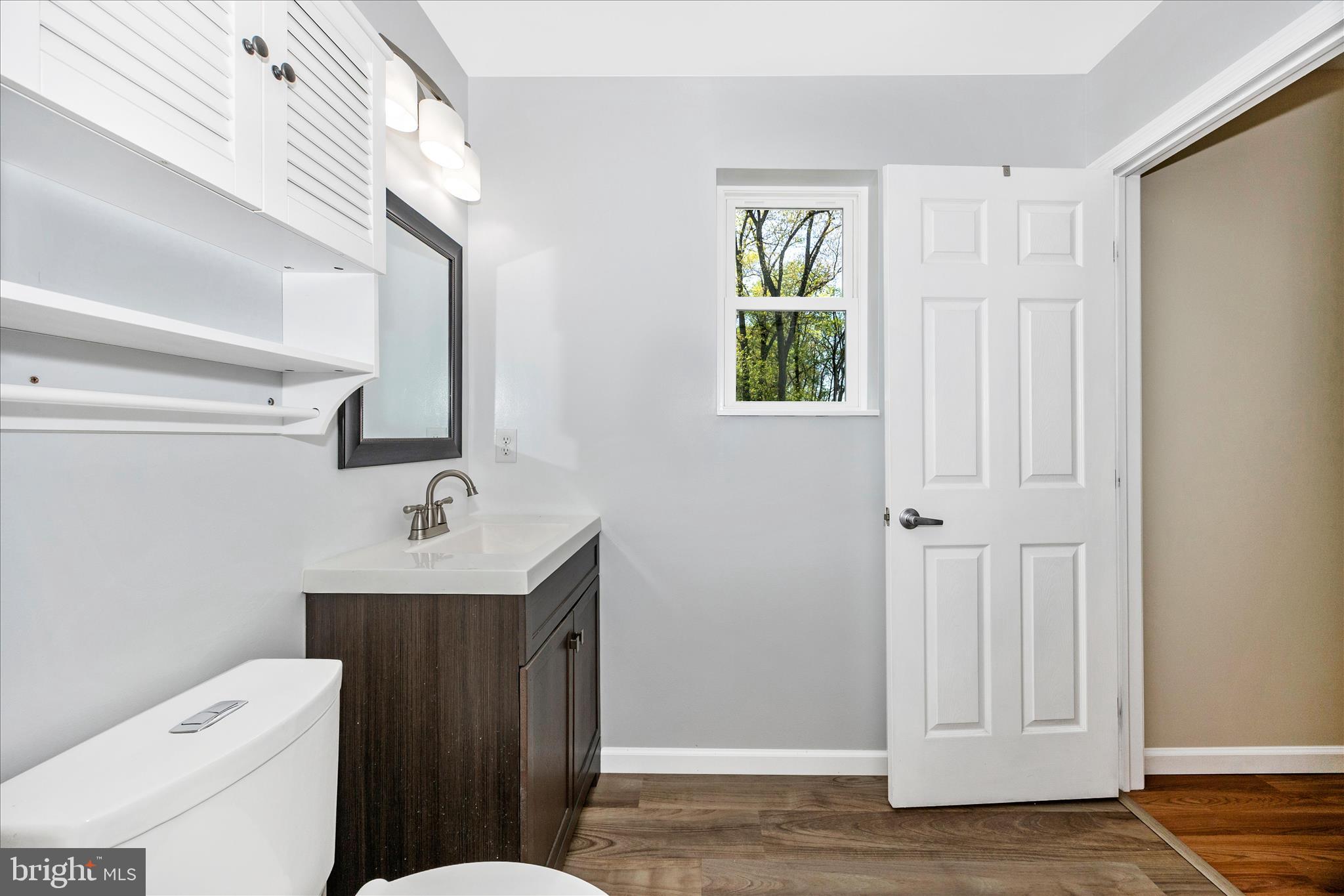 6518 Woodville Road Mount Airy, MD 21771 - Photo 29 of 53 a bathroom with a toilet a sink a vanity and mirror