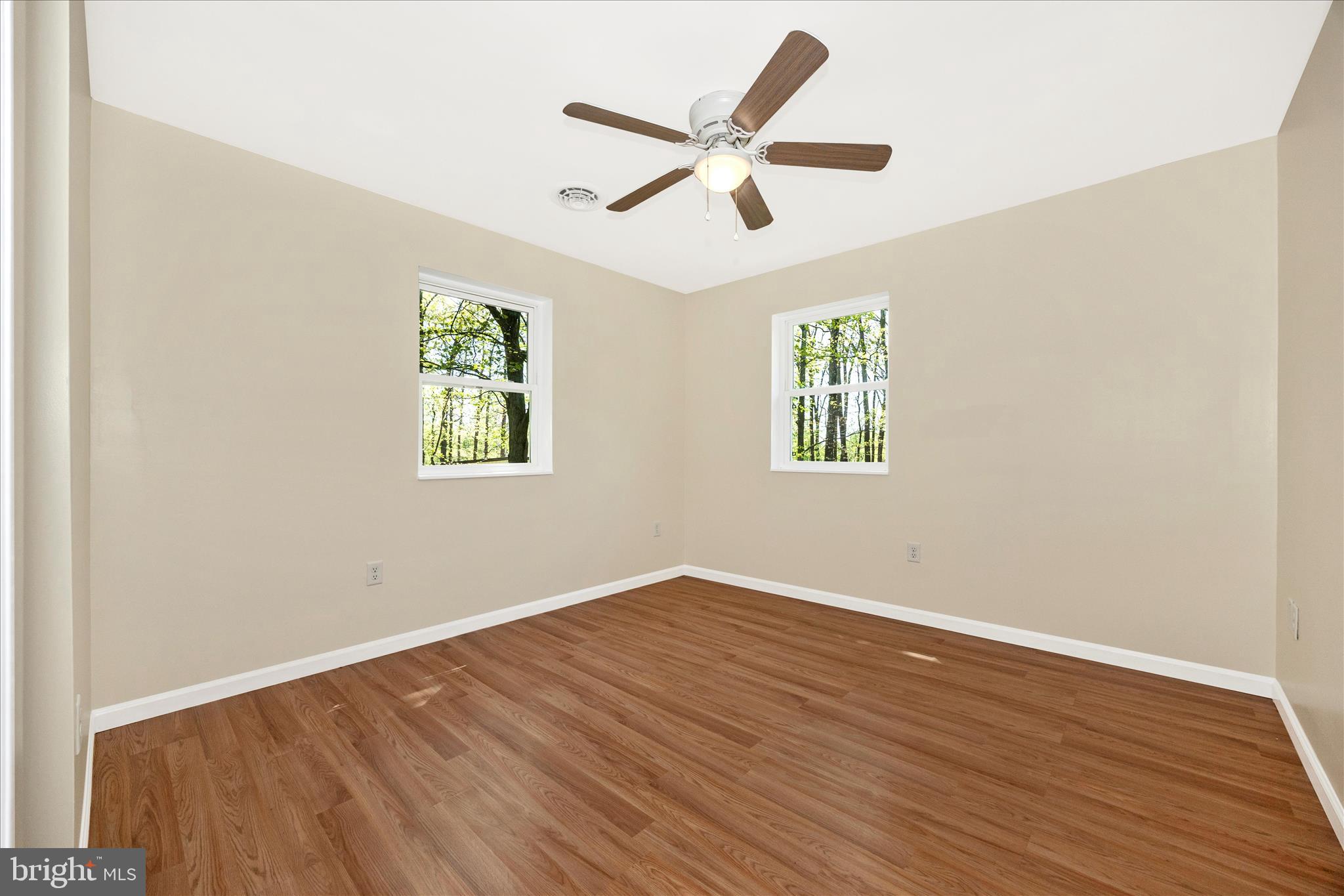 6518 Woodville Road Mount Airy, MD 21771 - Photo 30 of 53 an empty room with wooden floor ceiling fan and window