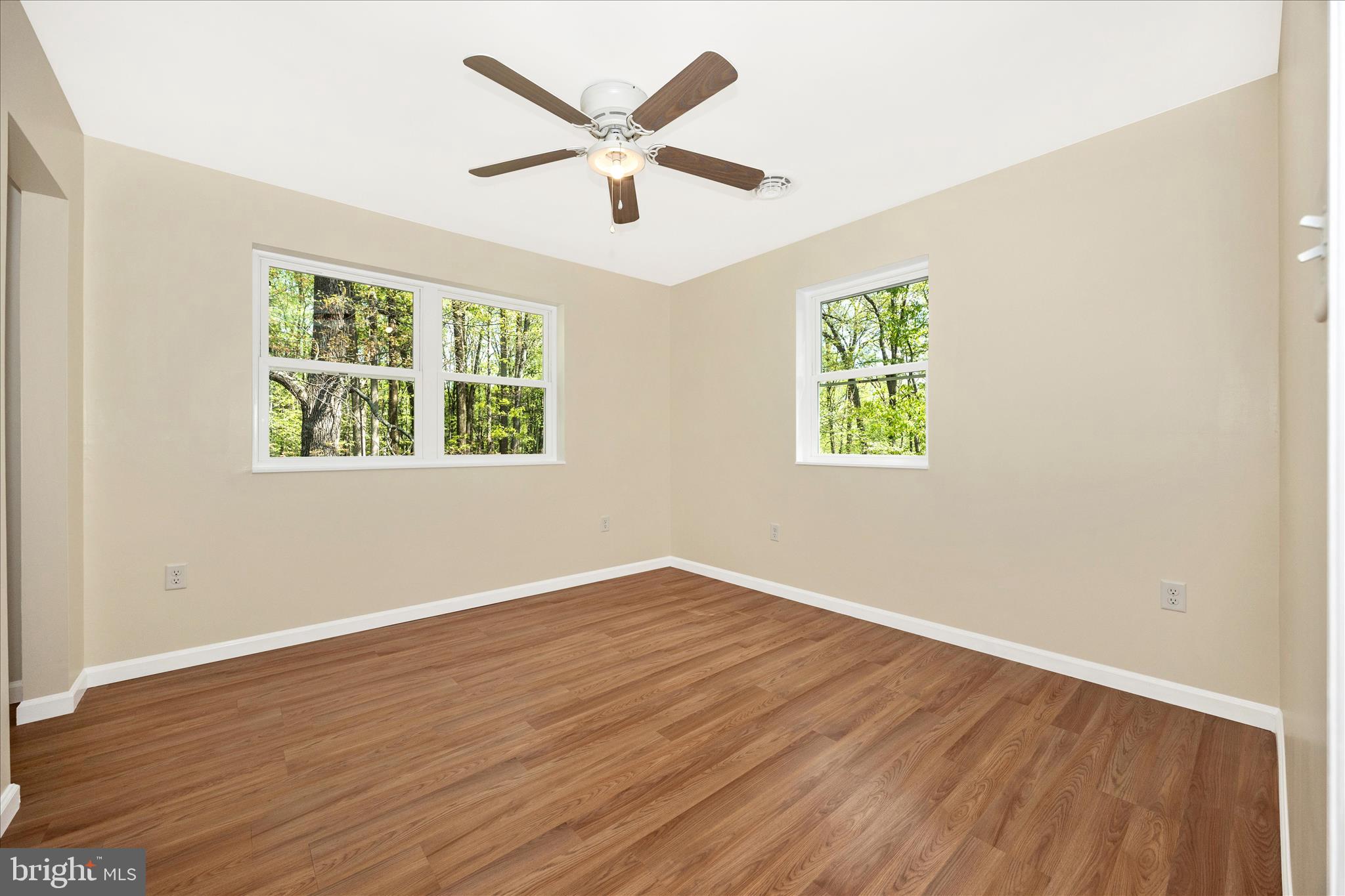 6518 Woodville Road Mount Airy, MD 21771 - Photo 31 of 53 a view of an empty room with wooden floor and a window