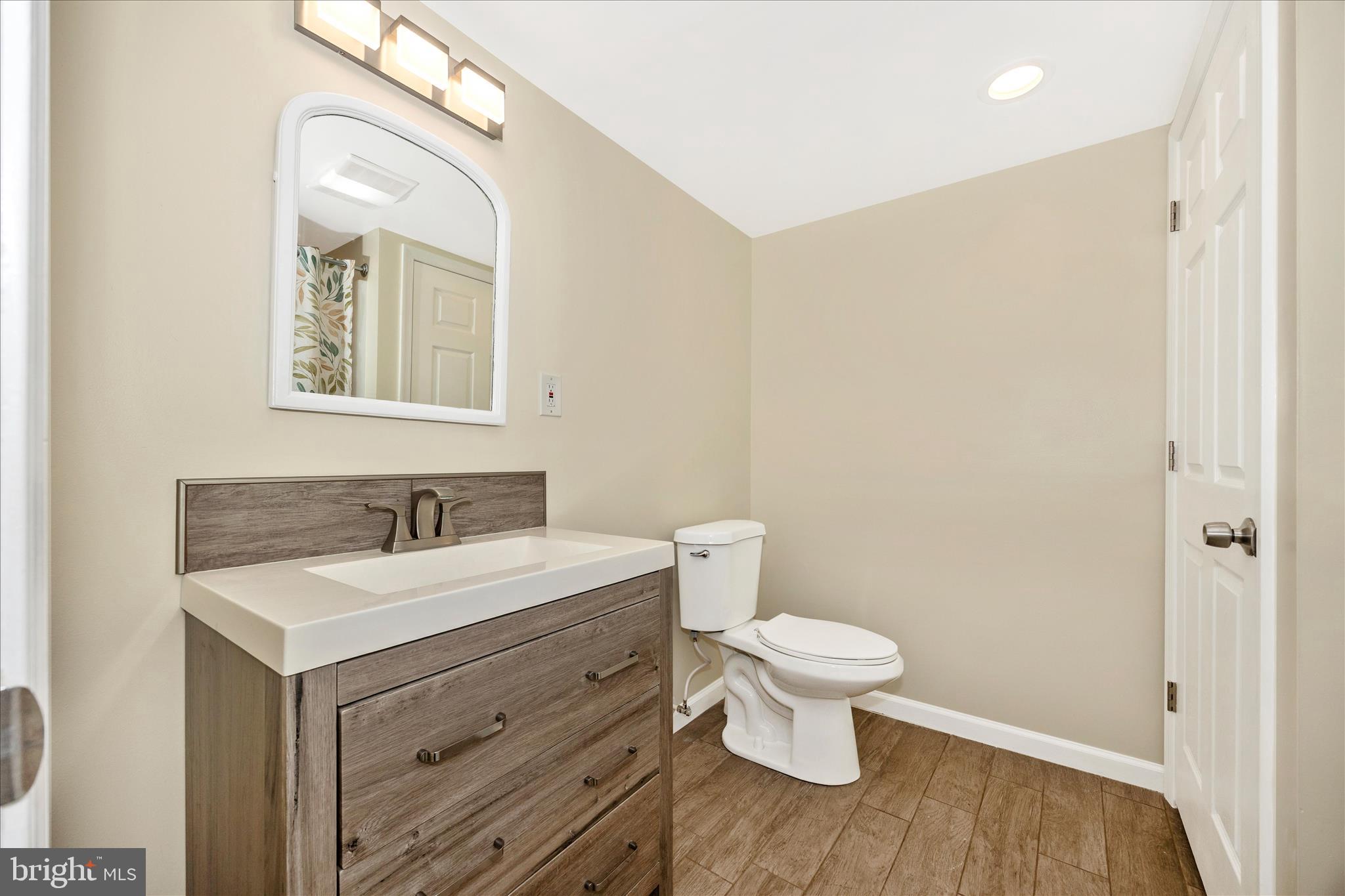 6518 Woodville Road Mount Airy, MD 21771 - Photo 36 of 53 a bathroom with a granite countertop sink mirror and a toilet