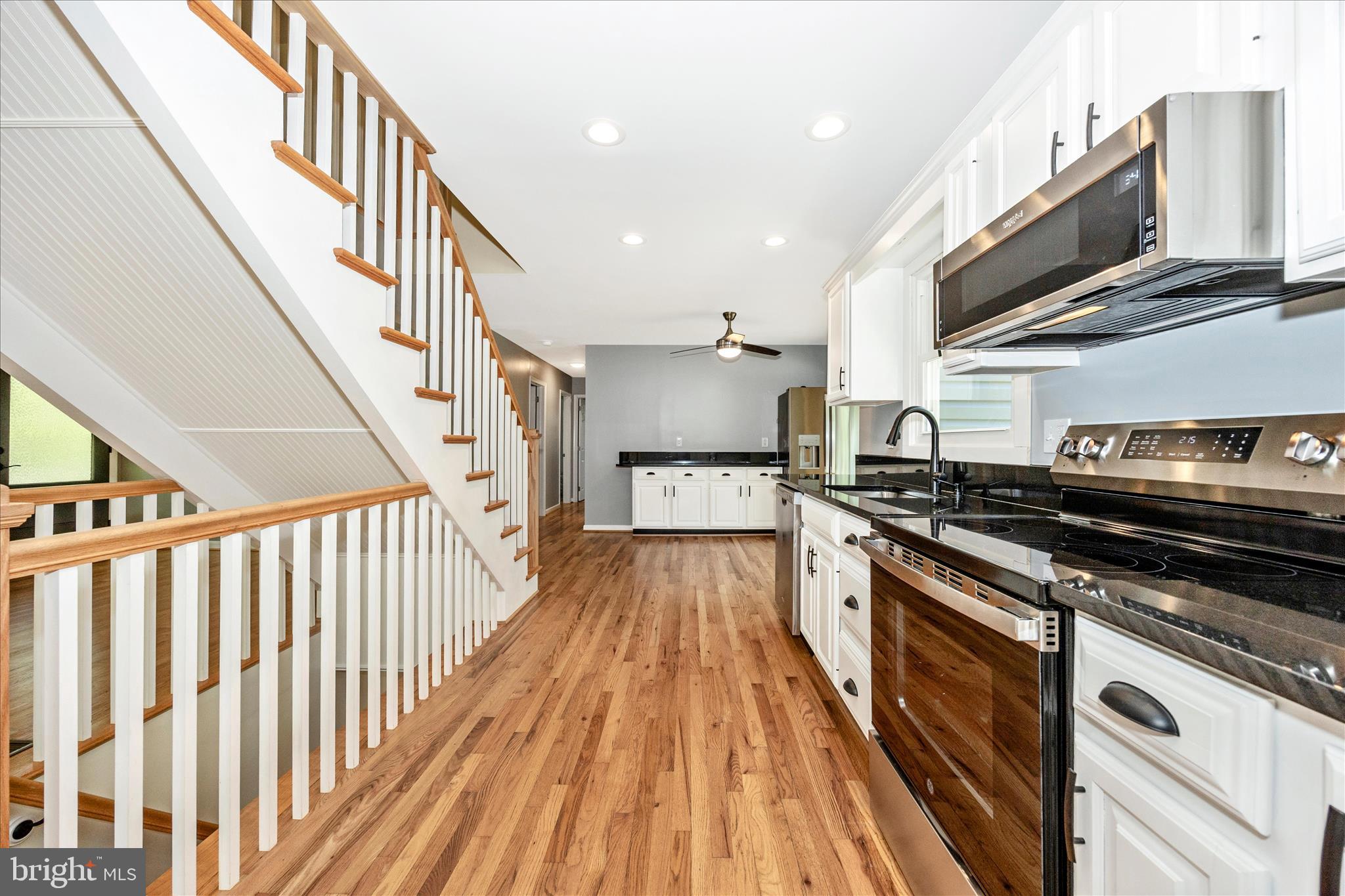 6518 Woodville Road Mount Airy, MD 21771 - Photo 9 of 53 a kitchen with wooden floors and stainless steel appliances