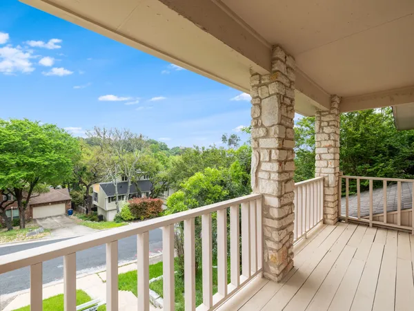 a view of a balcony with wooden floor and iron fence