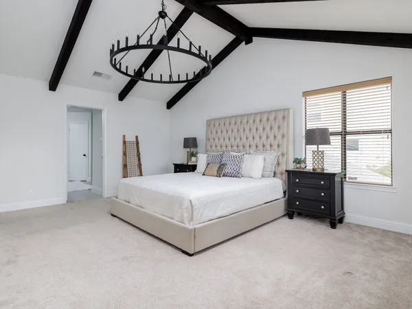 a bedroom with a bed and a chandelier