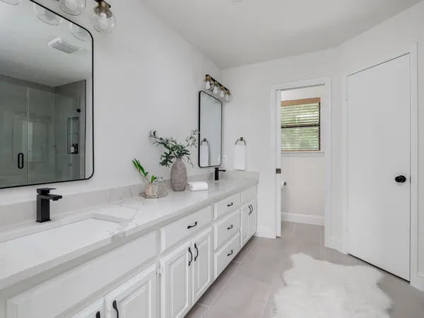 a bathroom with double sink and mirror