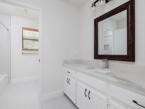 a bathroom with a granite countertop sink vanity and mirror