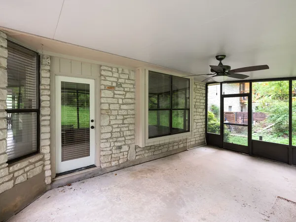 a view of an empty room with windows and a fireplace