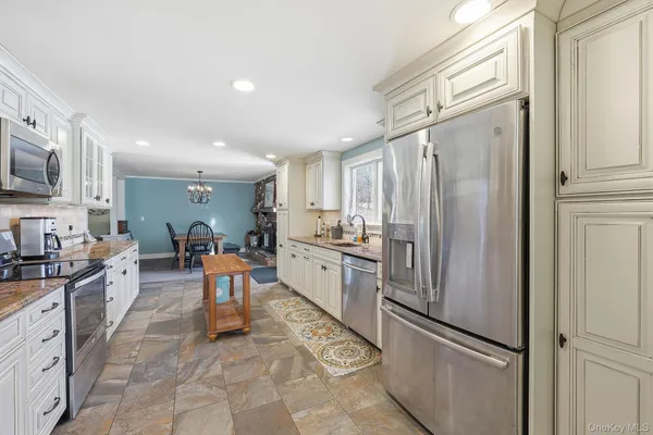 a kitchen with stainless steel appliances granite countertop a refrigerator and a stove top oven
