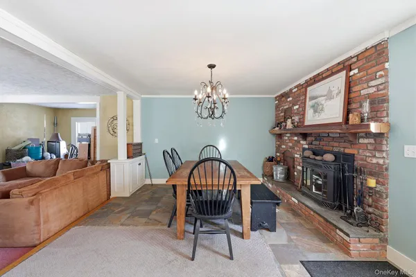 a living room with furniture a dining table and a fireplace