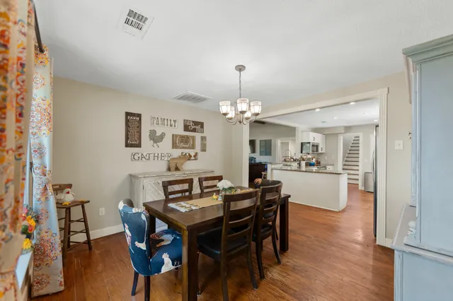 a view of a dining room with furniture a chandelier and wooden floor