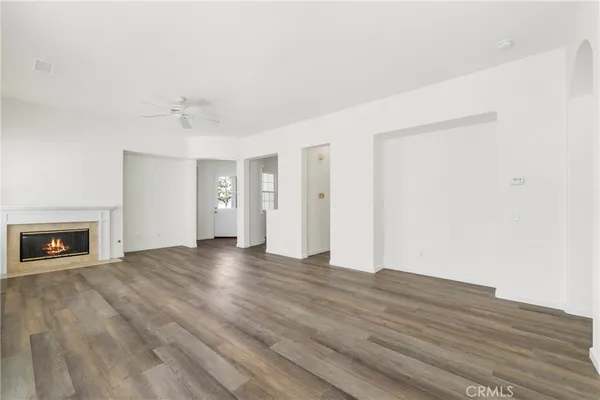 a view of empty room with wooden floor and fireplace