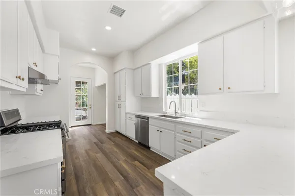 a kitchen with a sink a window and cabinets