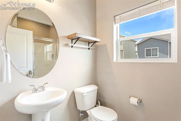 a bathroom with a toilet sink and mirror