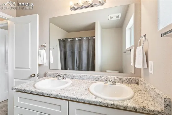 a bathroom with a granite countertop sink and a mirror