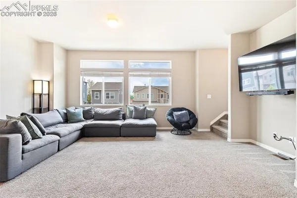 a living room with furniture a flat screen tv and a large window