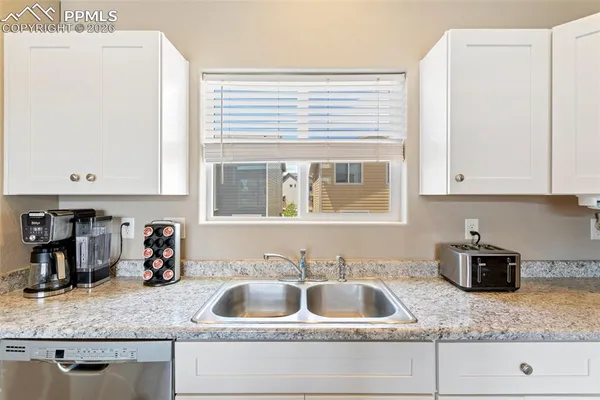 a kitchen with granite countertop a sink and a wooden floor