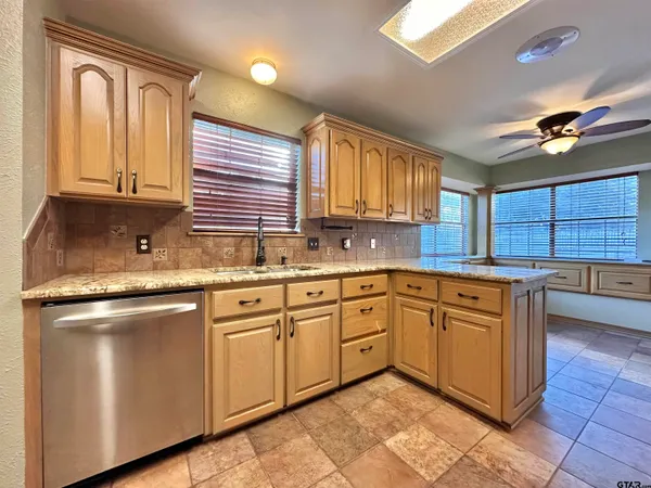 a kitchen with stainless steel appliances granite countertop a sink dishwasher stove and cabinets