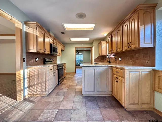 a kitchen with stainless steel appliances granite countertop a stove sink and cabinets