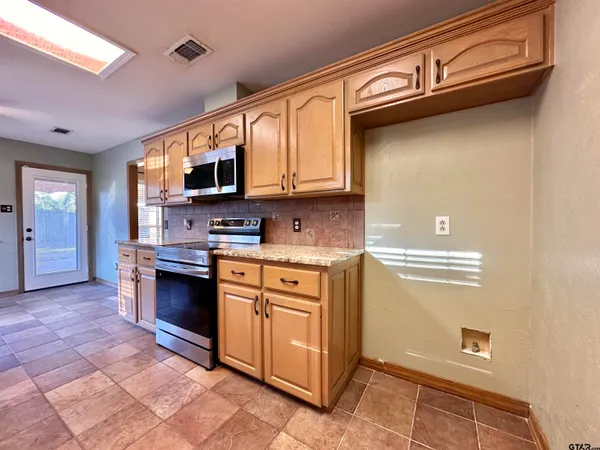 a kitchen with stainless steel appliances granite countertop a stove and a sink