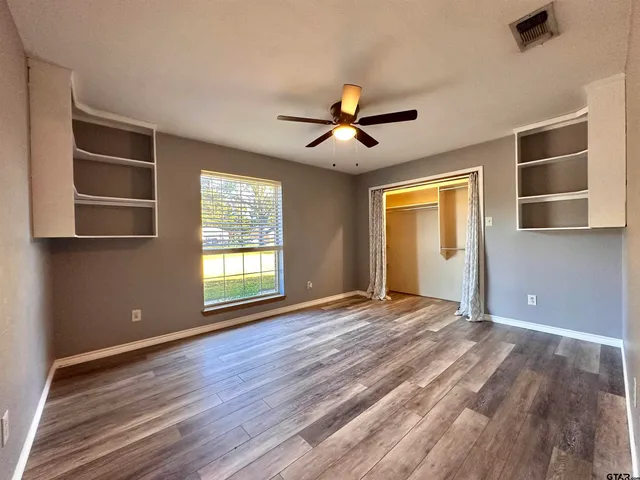 a view of empty room with a window and wooden floor