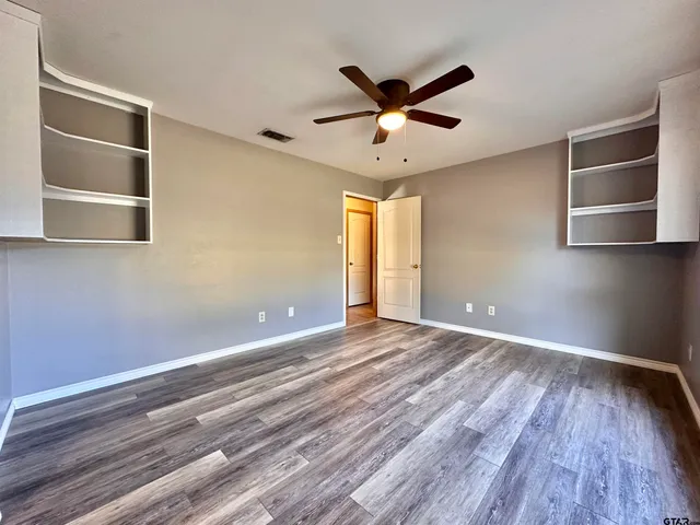 a view of empty room with wooden floor and window