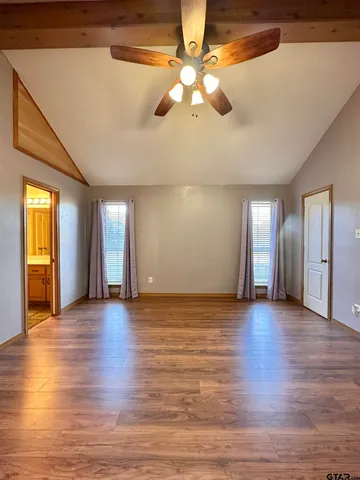 a view of an empty room with window and wooden floor