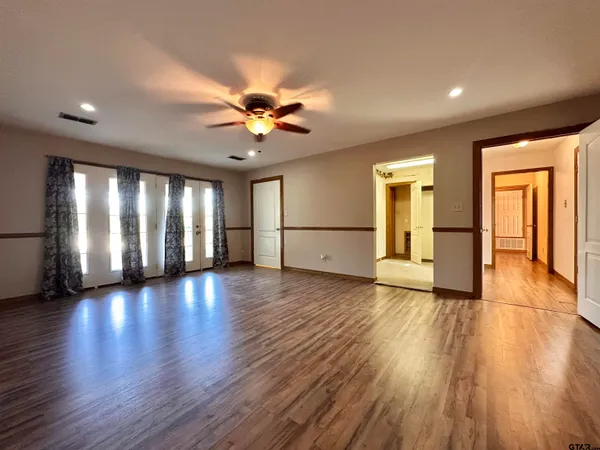a view of an empty room with window and wooden floor