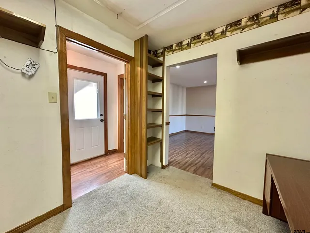 a view of a hallway with wooden shelves