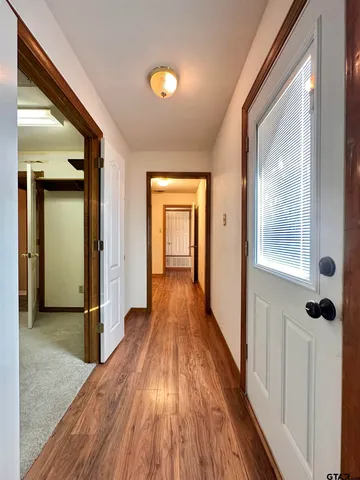 a view of a hallway with wooden floor and staircase