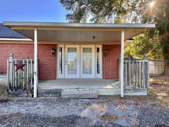 a view of a house with a yard and large tree