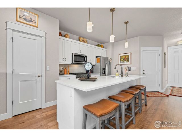 a open kitchen with stainless steel appliances a stove sink refrigerator dining table and chairs