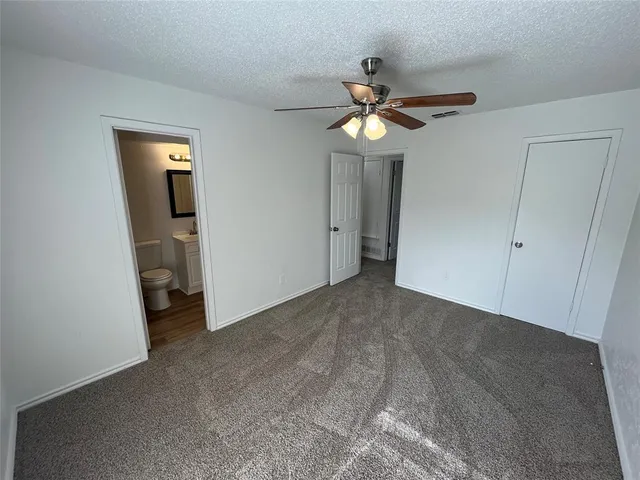 a view of an empty room with a chandelier fan