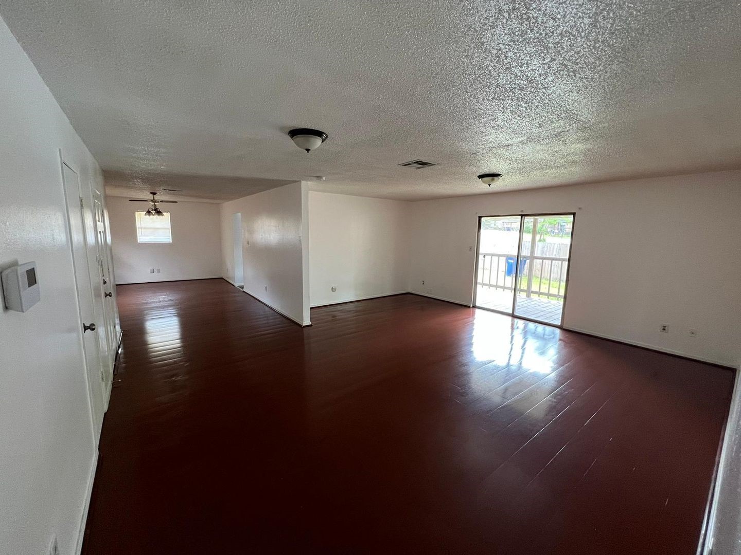 3058 Old Colony Road Huntsville, TX 77320 - Photo 3 of 14 an empty room with wooden floor and windows