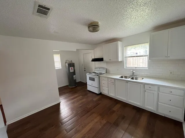 a kitchen with cabinets wooden floor and a sink