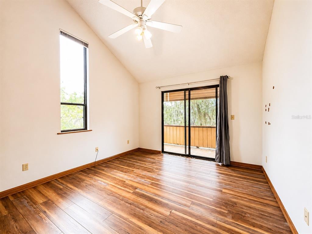 7119 Immokalee Road Keystone Heights, FL 32656 - Photo 24 of 50 an empty room with wooden floor fan and windows