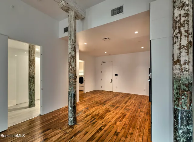 a view of empty room with wooden floor