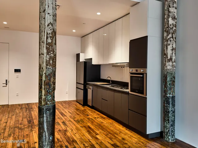 a kitchen with granite countertop a refrigerator and a stove