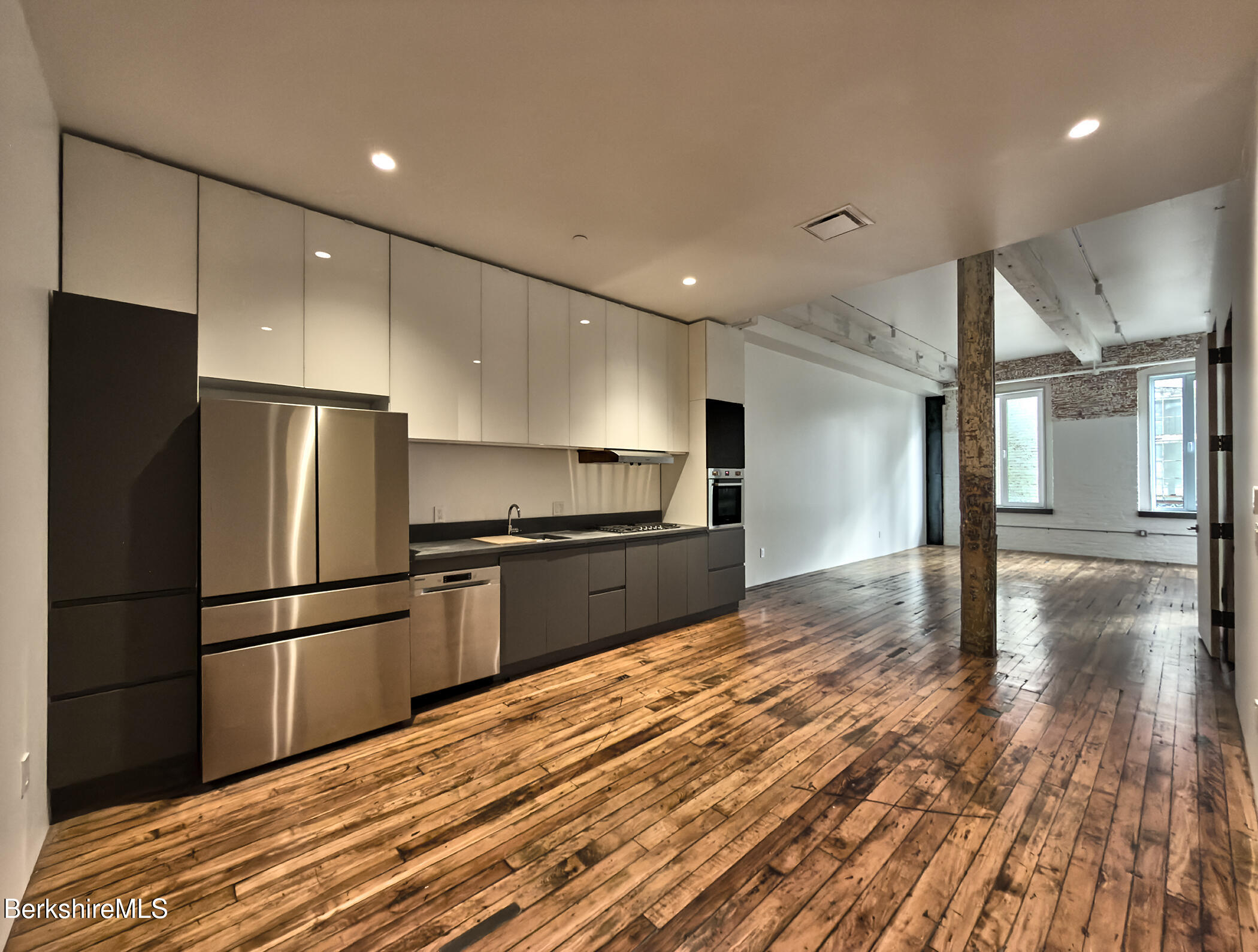 520 State Road, Unit 206 North Adams, MA 01247 - Photo 4 of 16 a kitchen with granite countertop a refrigerator and a stove top oven