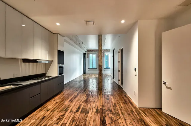 a view of a kitchen with wooden floor and electronic appliances