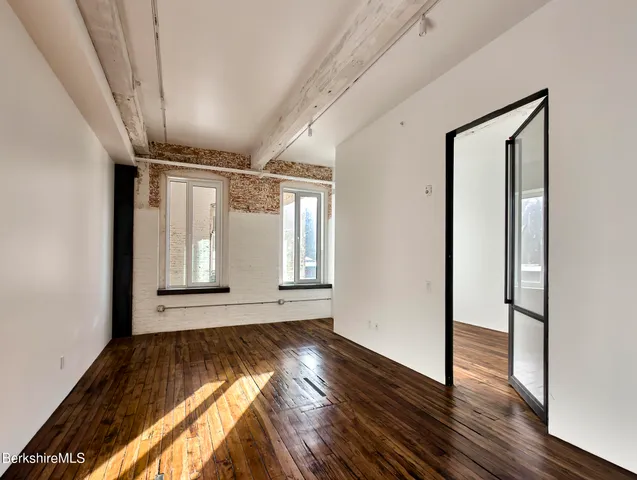 a view of empty room with wooden floor