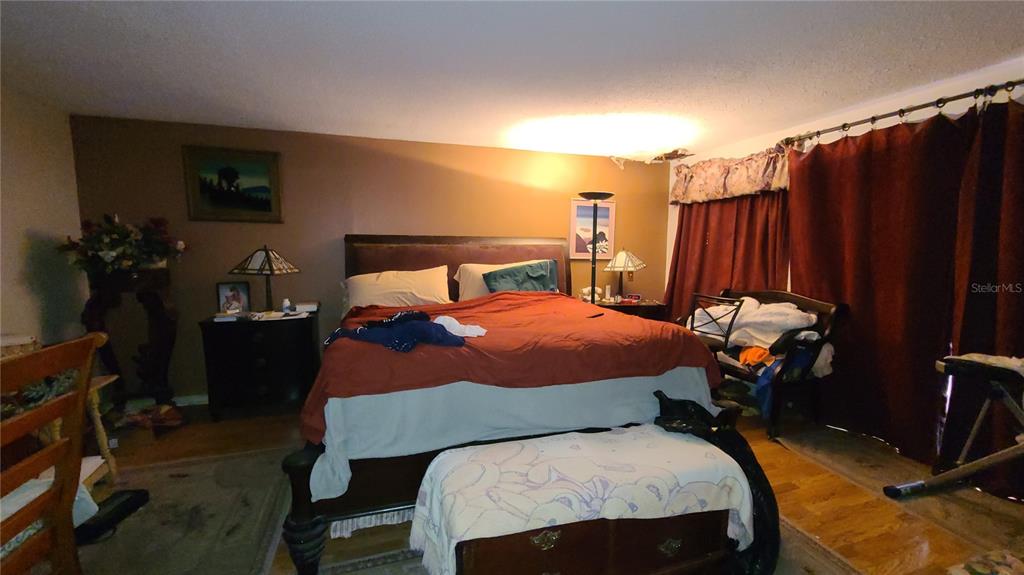 501 Hermits Trail Altamonte Springs, FL 32701 - Photo 13 of 61 a bedroom with a bed a lamp and potted plants on the table